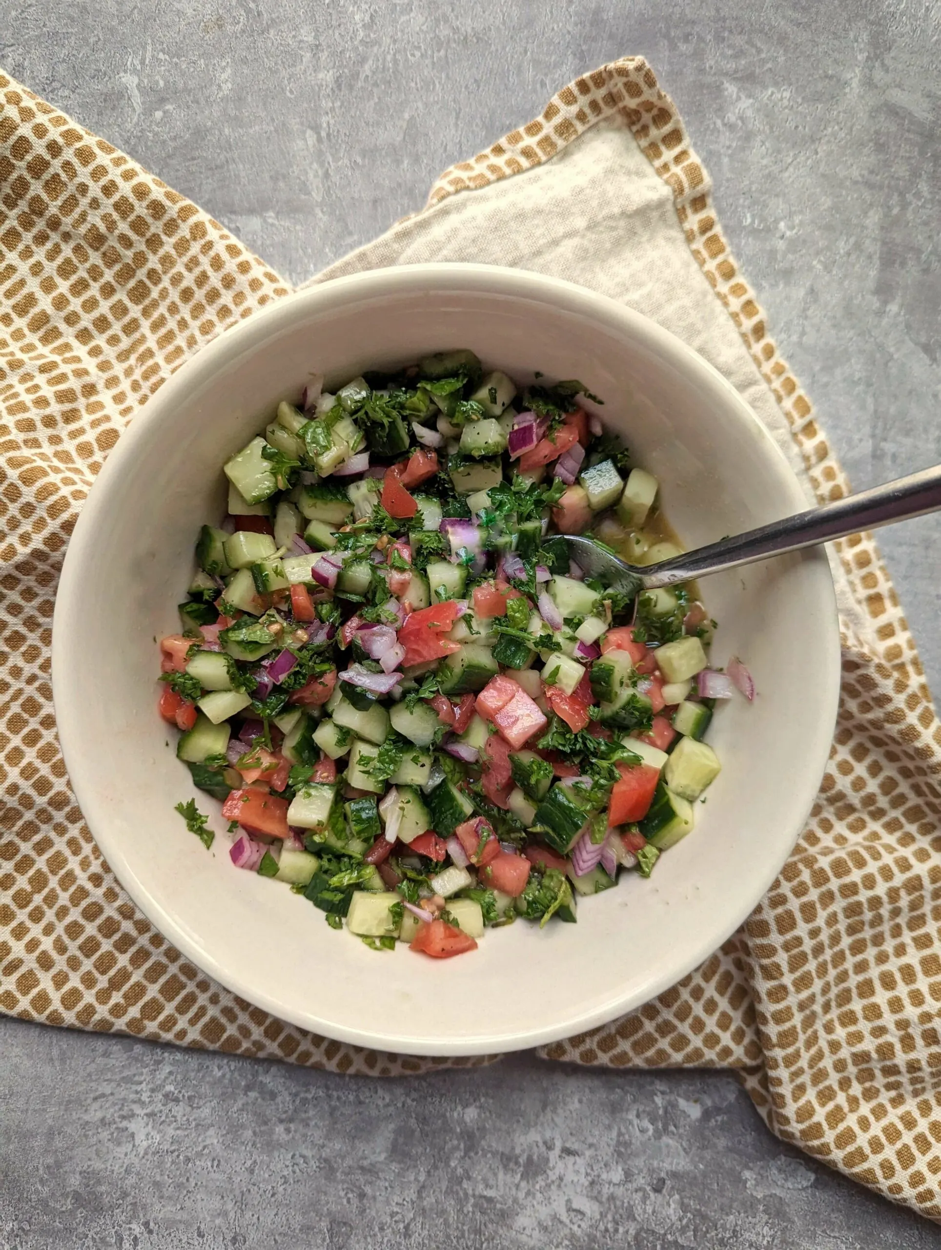 Shirazi salad tossed in a mixing bowl.