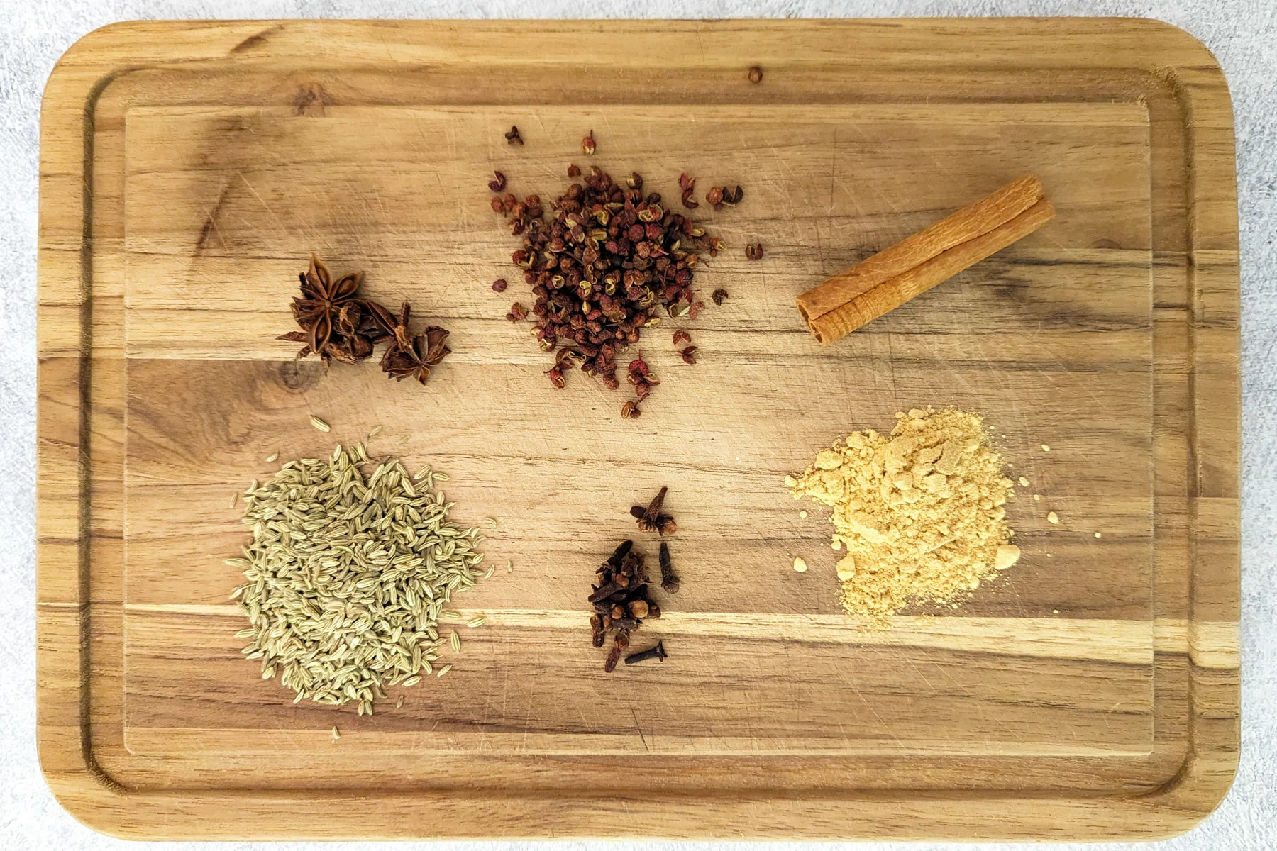 Ingredients for homemade chinese five spice on a cutting board.
