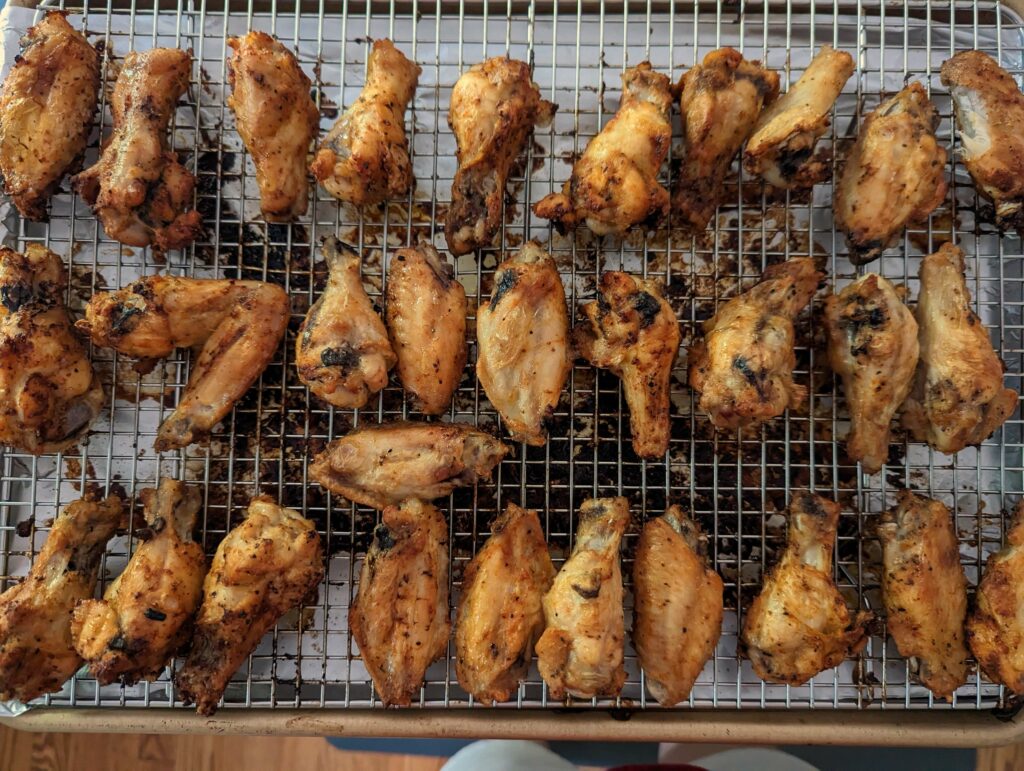 Wings lined onto a baking sheet and cooling.