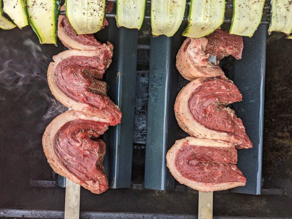 Grilled picanha cooking on the grill.