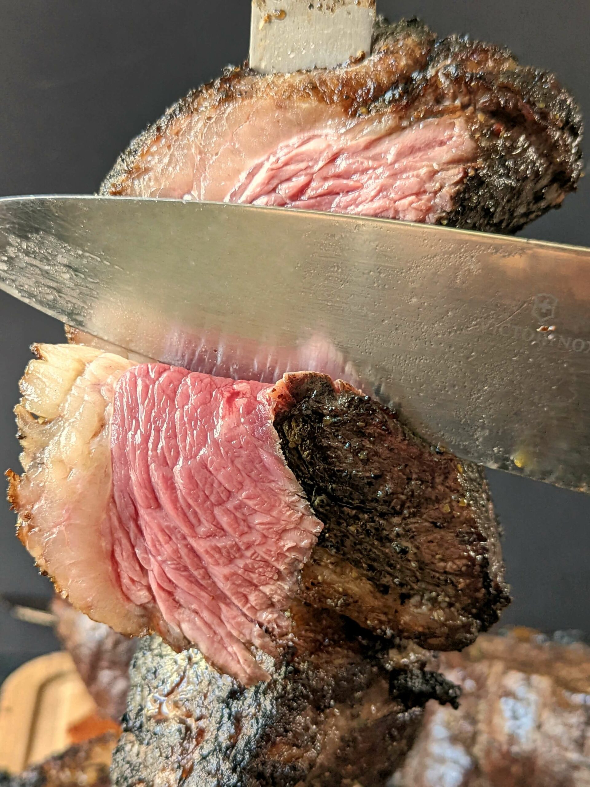 A knife cutting a picanha steak.