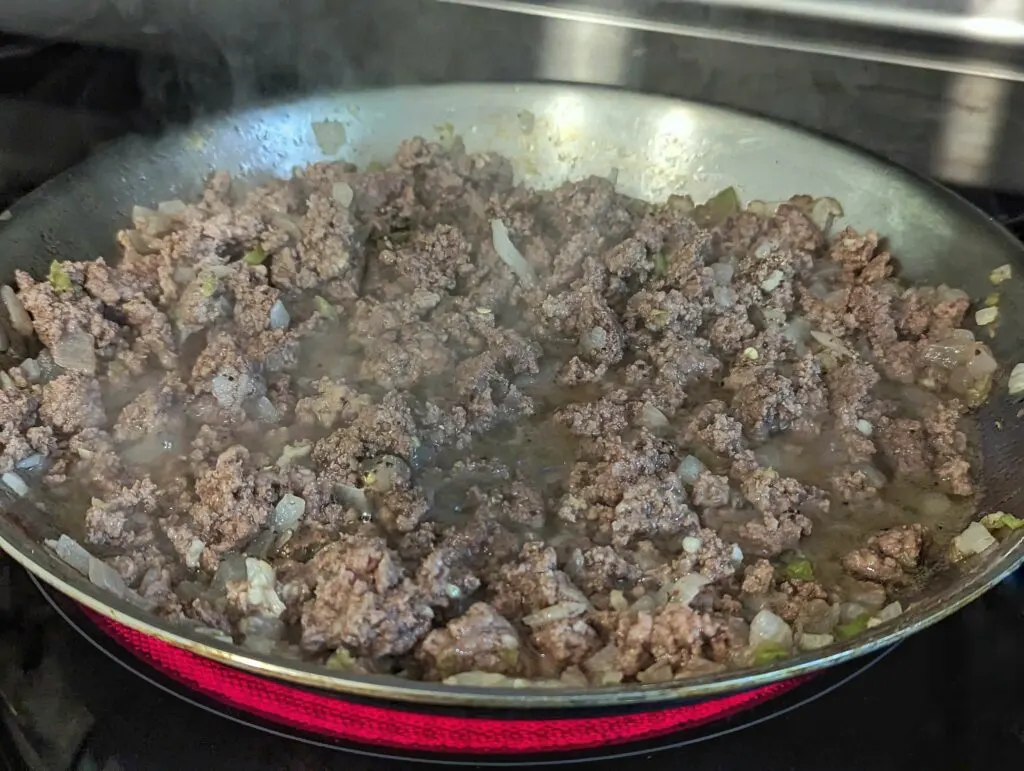 Ground beef and potatoes cooking with the onion mixture.