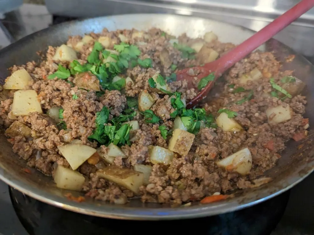 Cilantro added to the simmering beef mixture.
