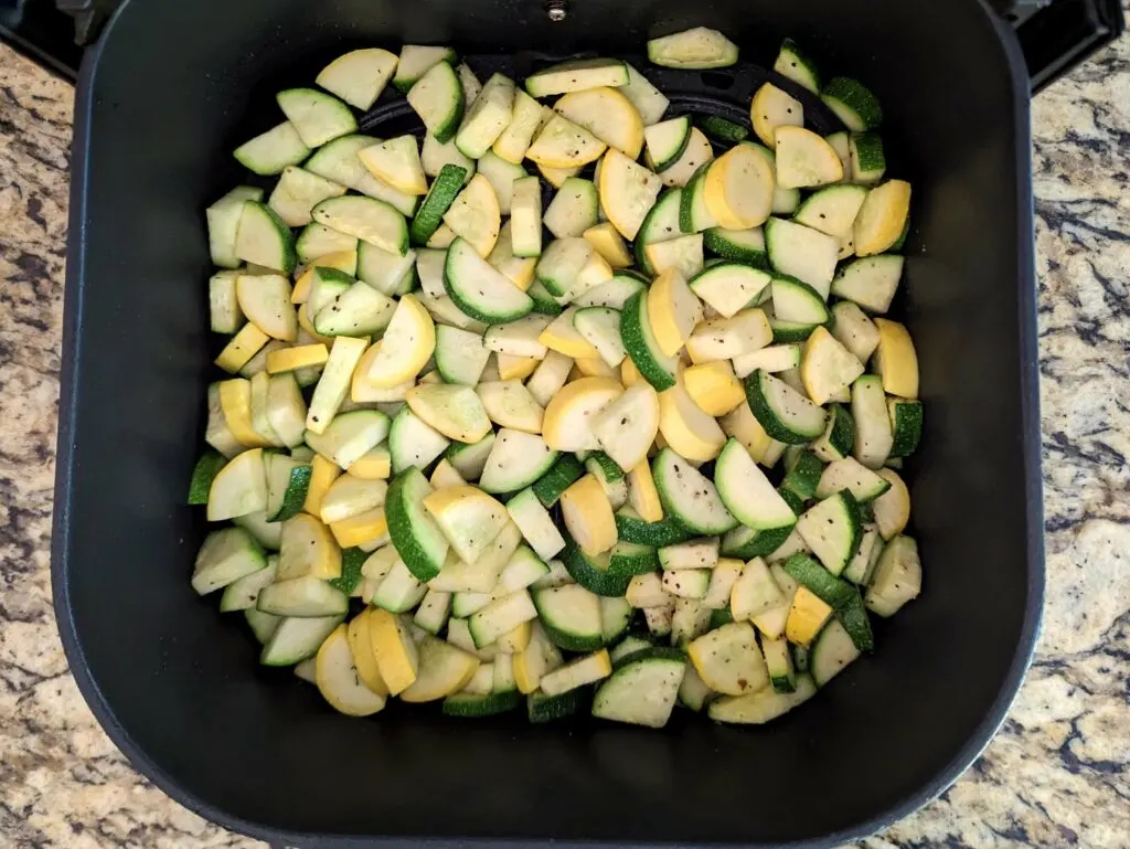 zucchini and squash cut and cooking in the air fryer.