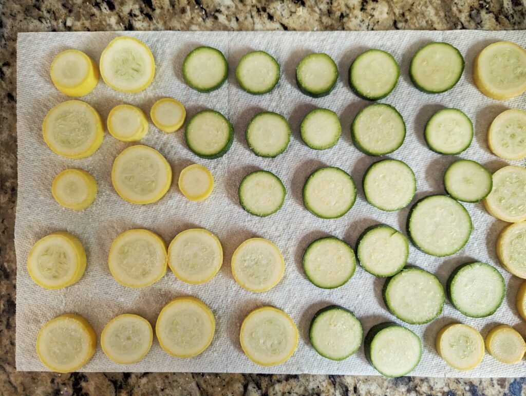 Salted zucchini and squash laying on a cloth.