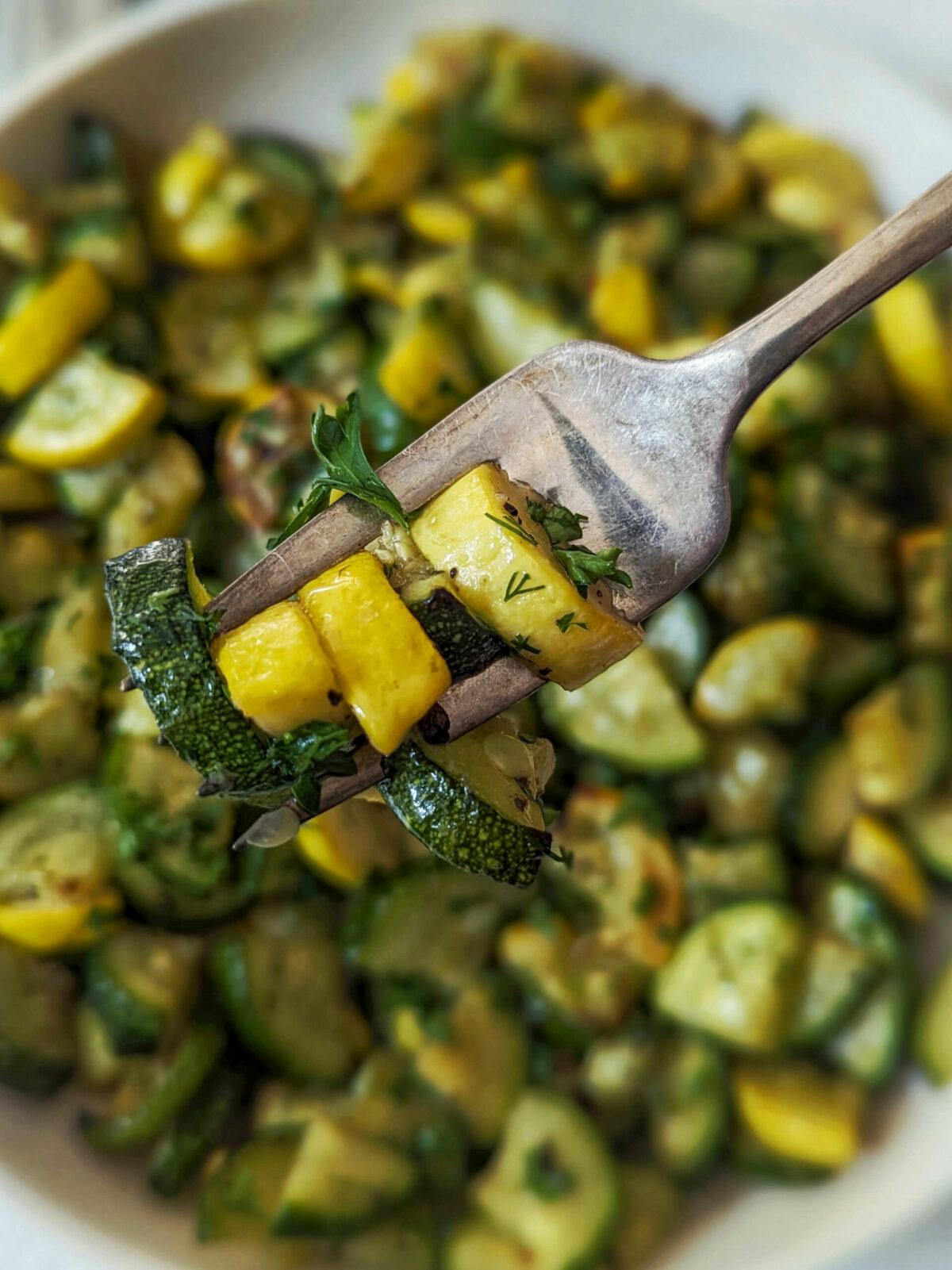 A scoop of zucchini and squash on a fork. 