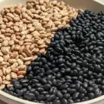 A serving bowl of dried pinto and black beans.
