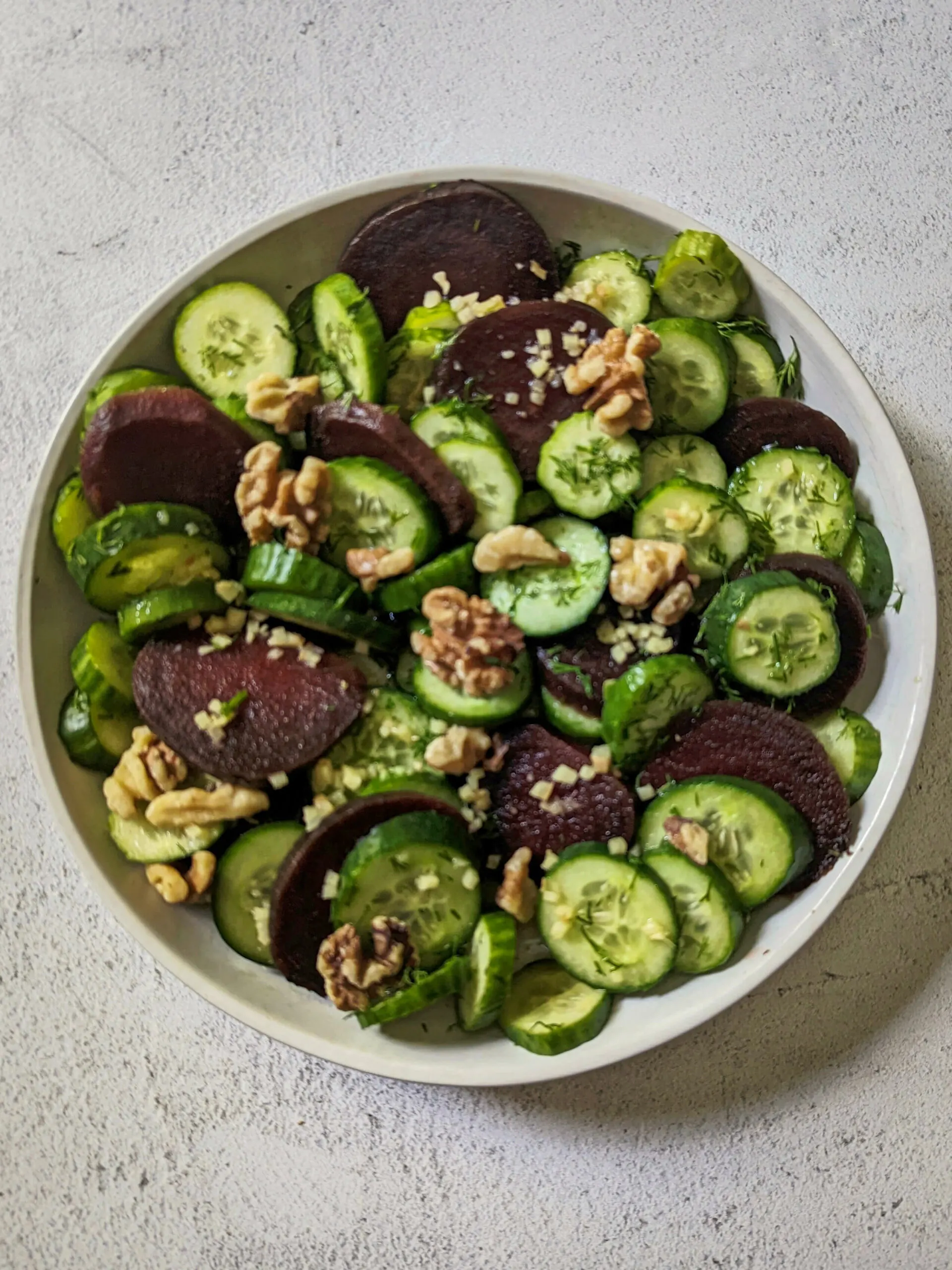 A zoomed out picture of the cucumber beet salad on a serving dish.