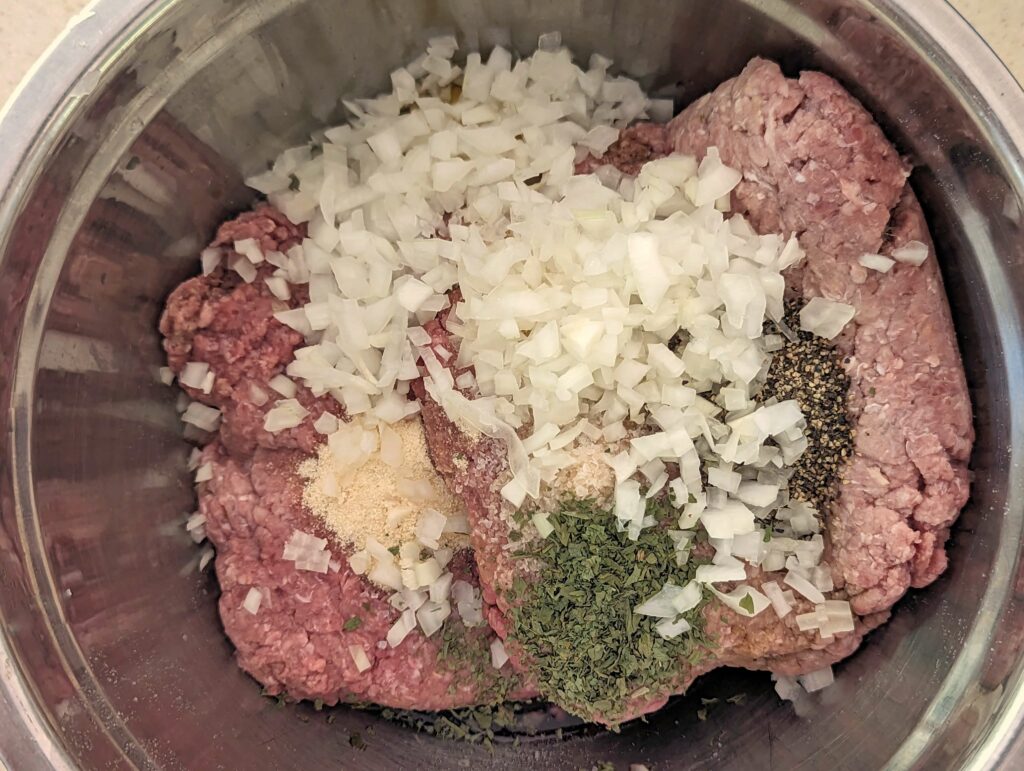 Ingredients for the baked meatballs in a mixing bowl.