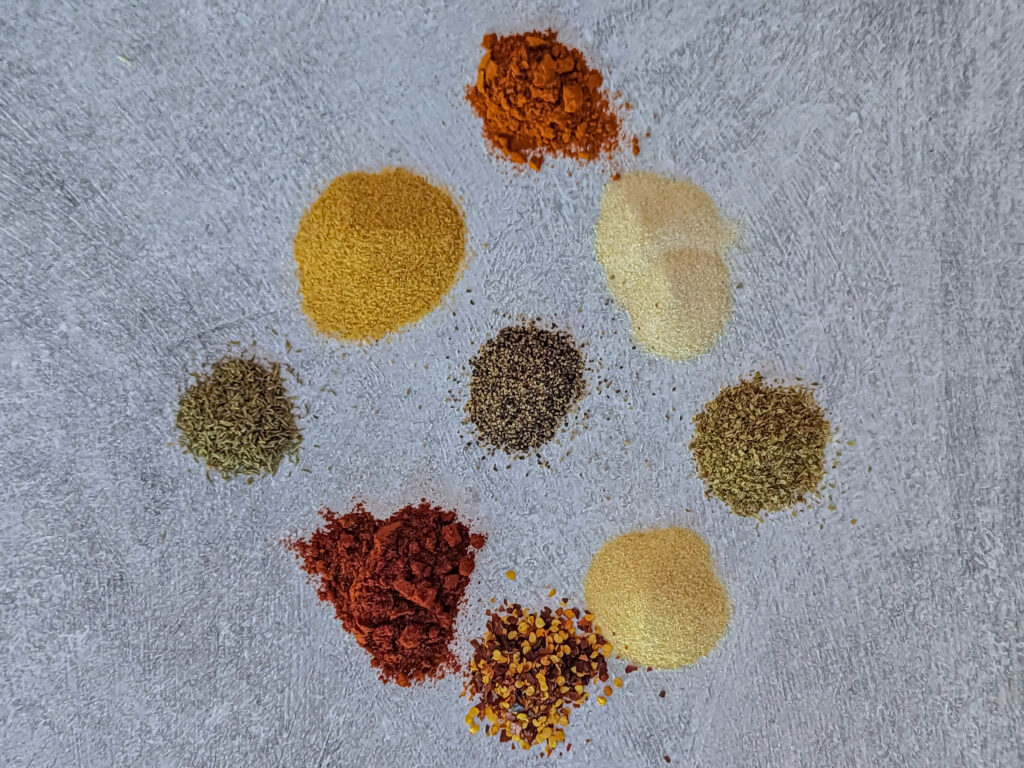 All of the spices for Slap Ya Mama Seasoning on a surface.