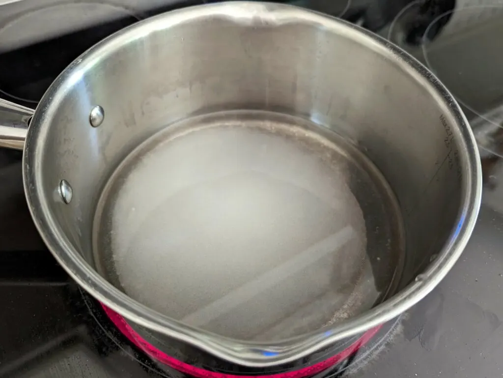Water and sugar in a saucepan.