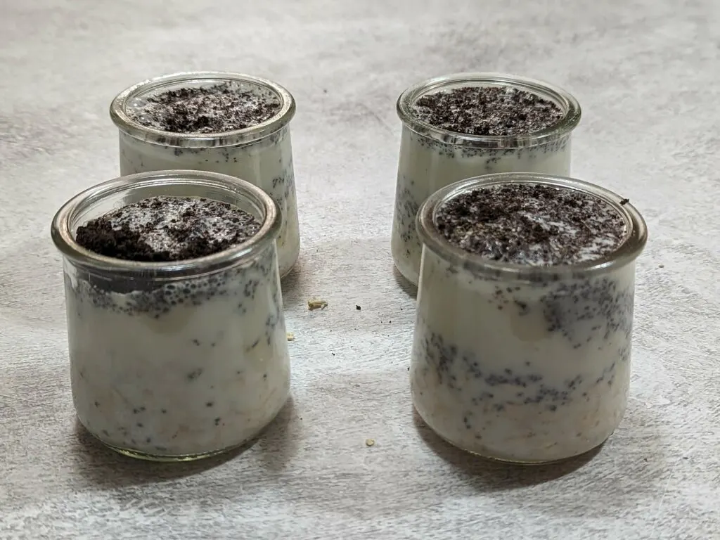 The ingredients for oreo overnight oats combined in small containers.