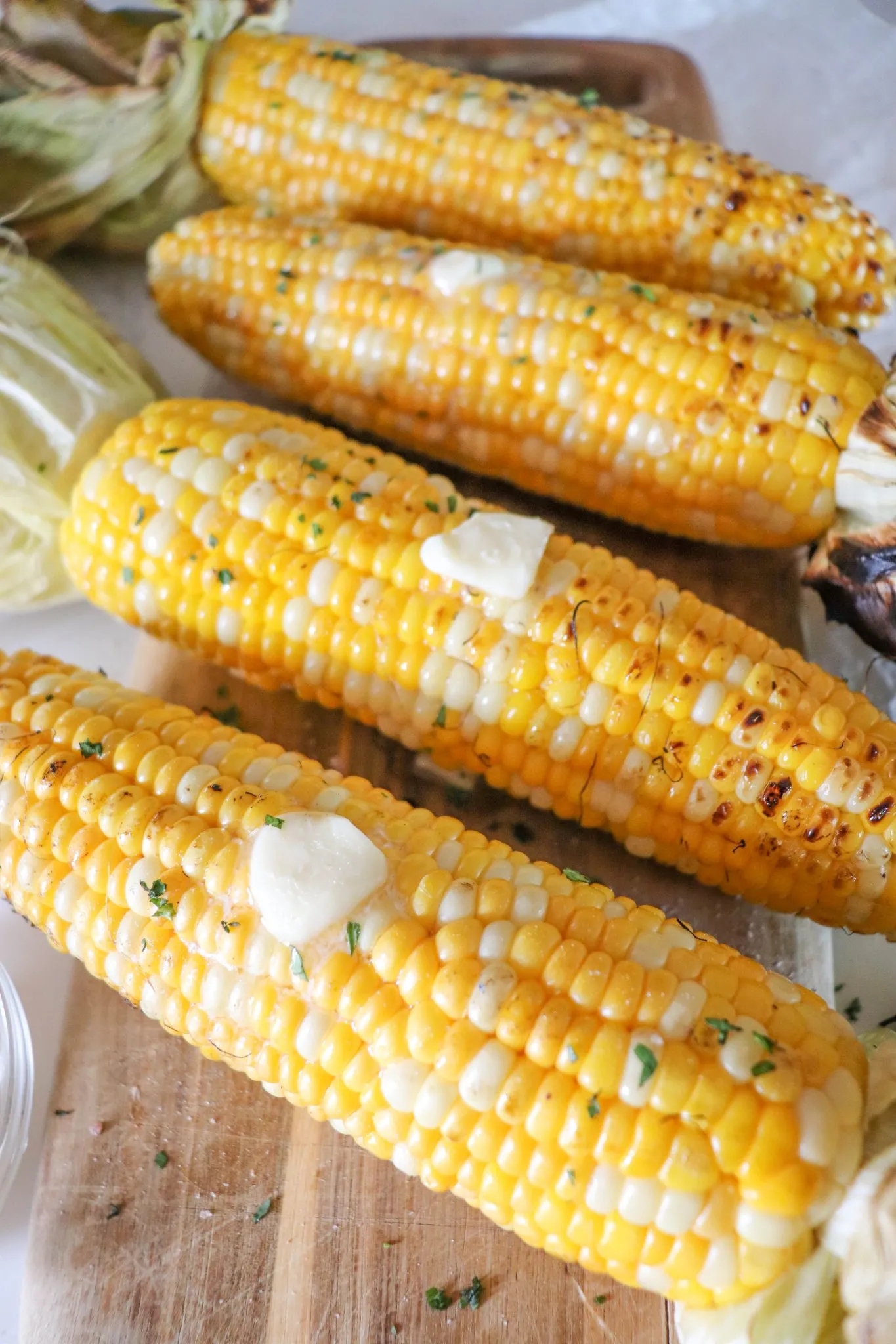 Four ears of corn on the cob flavored with butter.