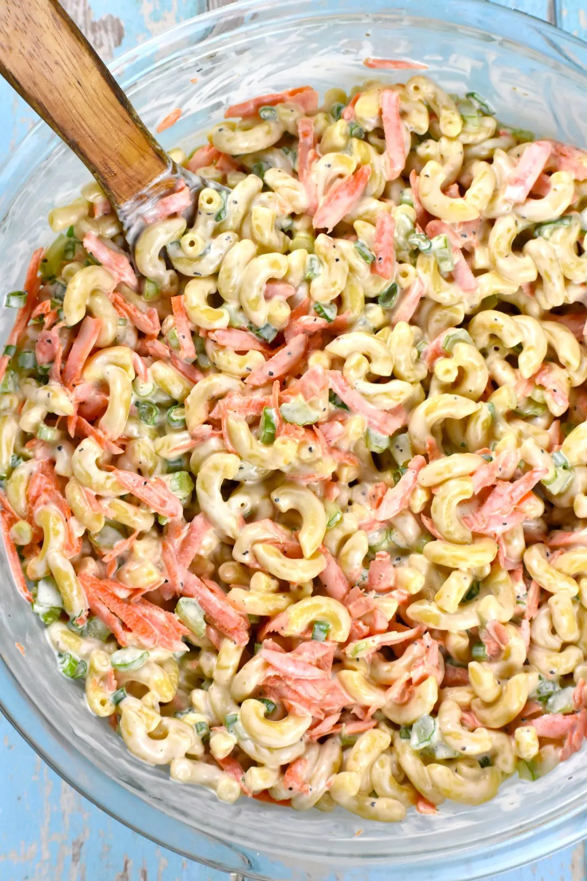 A serving bowl of Hawaiian macaroni salad with a large spoon in it.