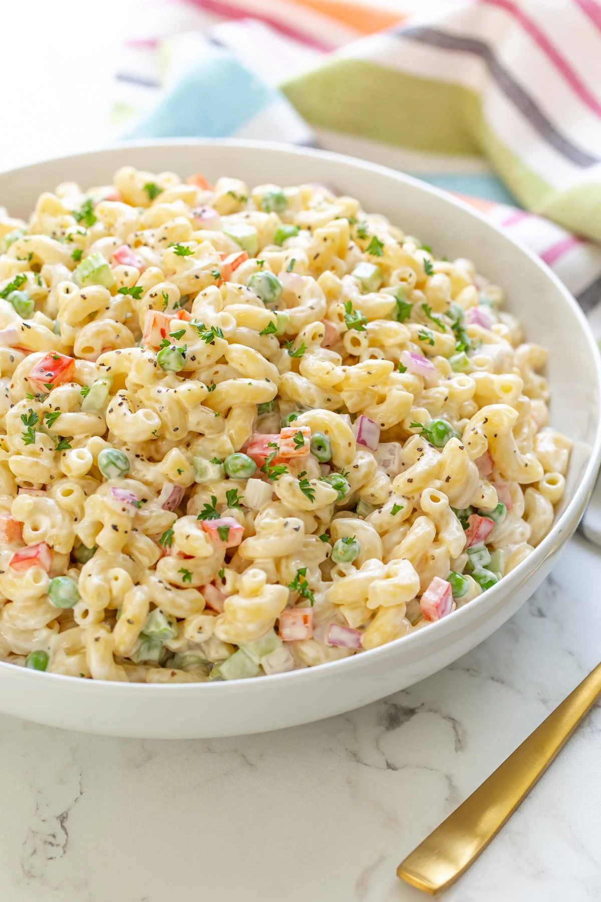 A side view of classic macaroni salad in a serving dish.