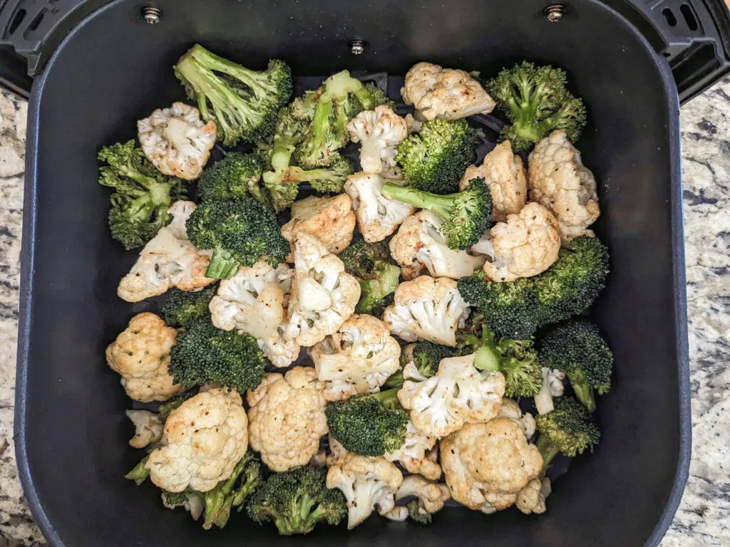 Broccoli and cauliflower in the air fryer basket.