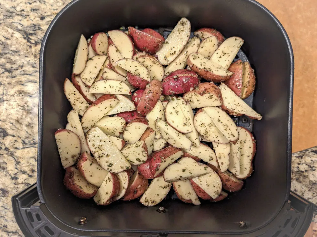 The air fryer red potatoes added to the air fryer basket.