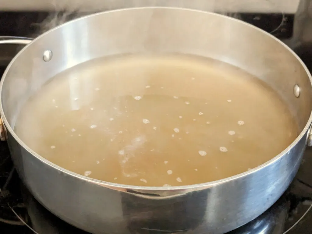 Broth boiling in a saute pan.