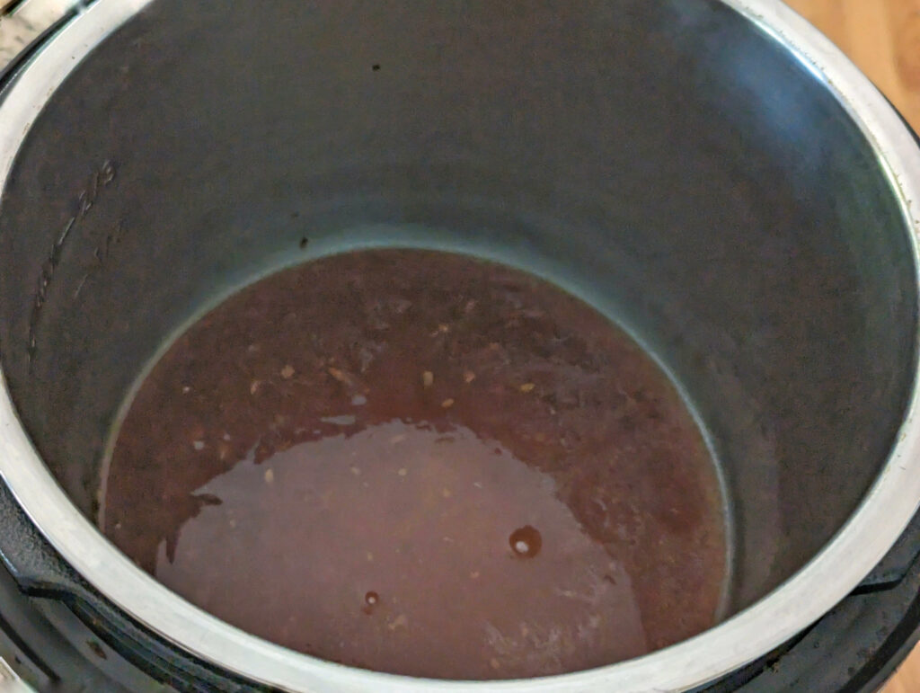 Teriyako sauce in the bottom of an Instant Pot.