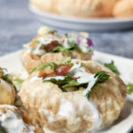 Our pani puri recipe on a serving plate and garnished with dahi and chaat masala.