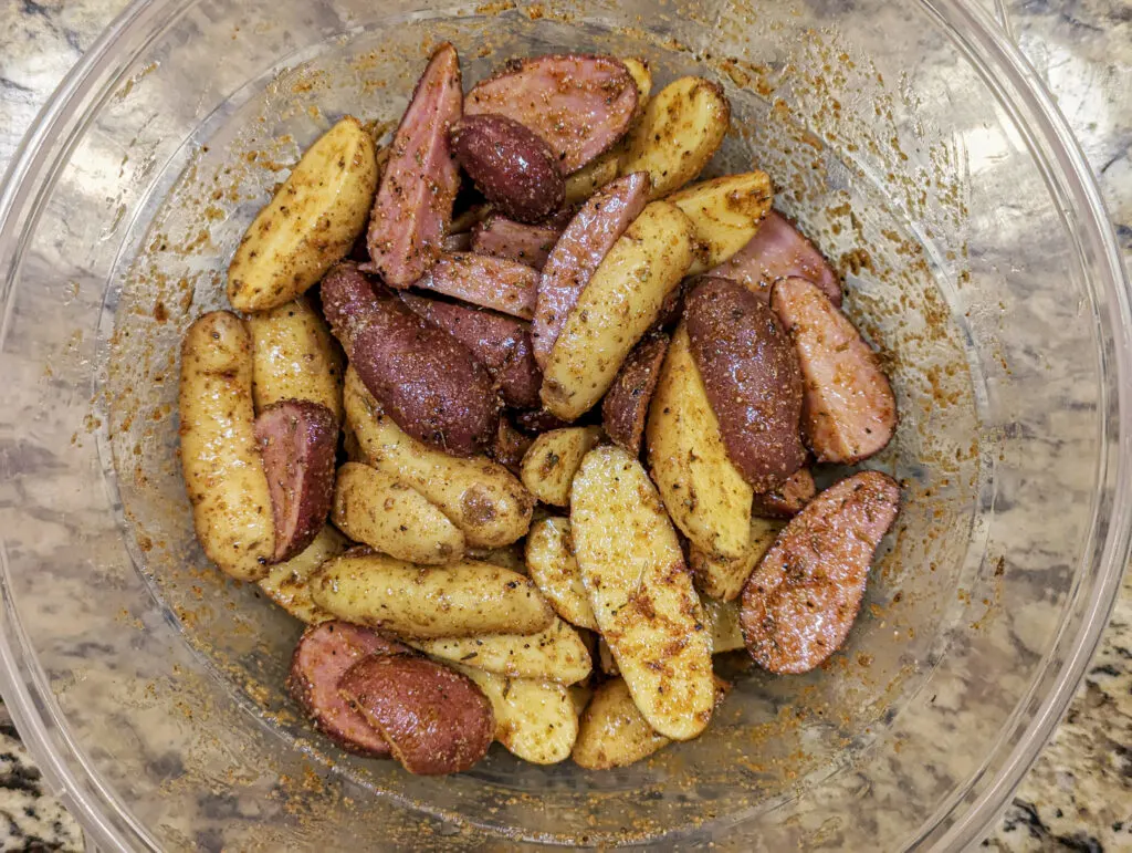 Fingerling Potatoes in a mixing bowl with spices.