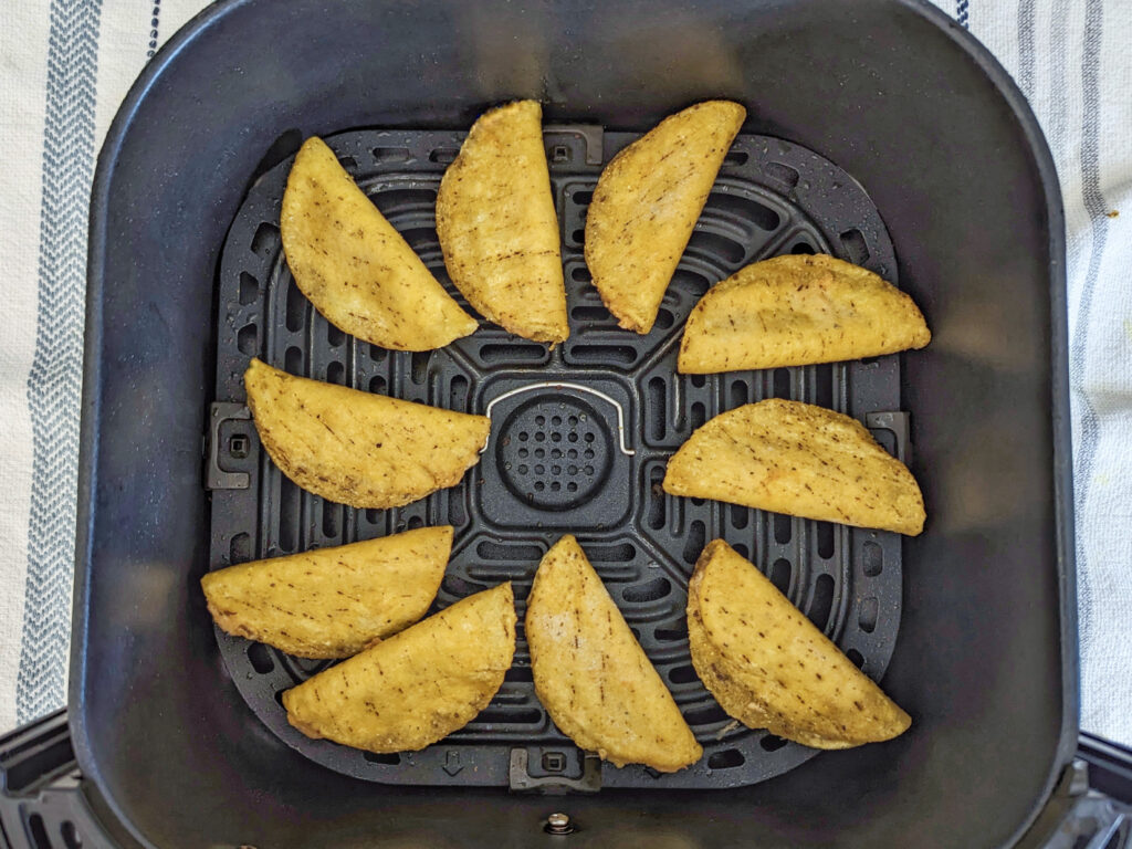 Mini tacos lined into the air fryer basket.