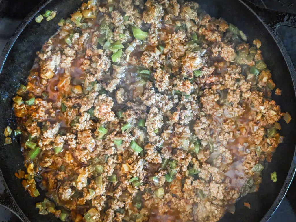 Ground beef cooking with the vegetables.