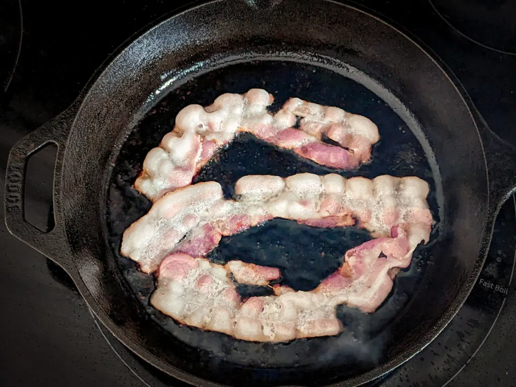 Bacon searing in a skillet.