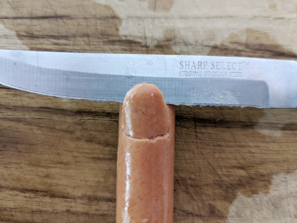 A paring knife slid under the hotdog skin.