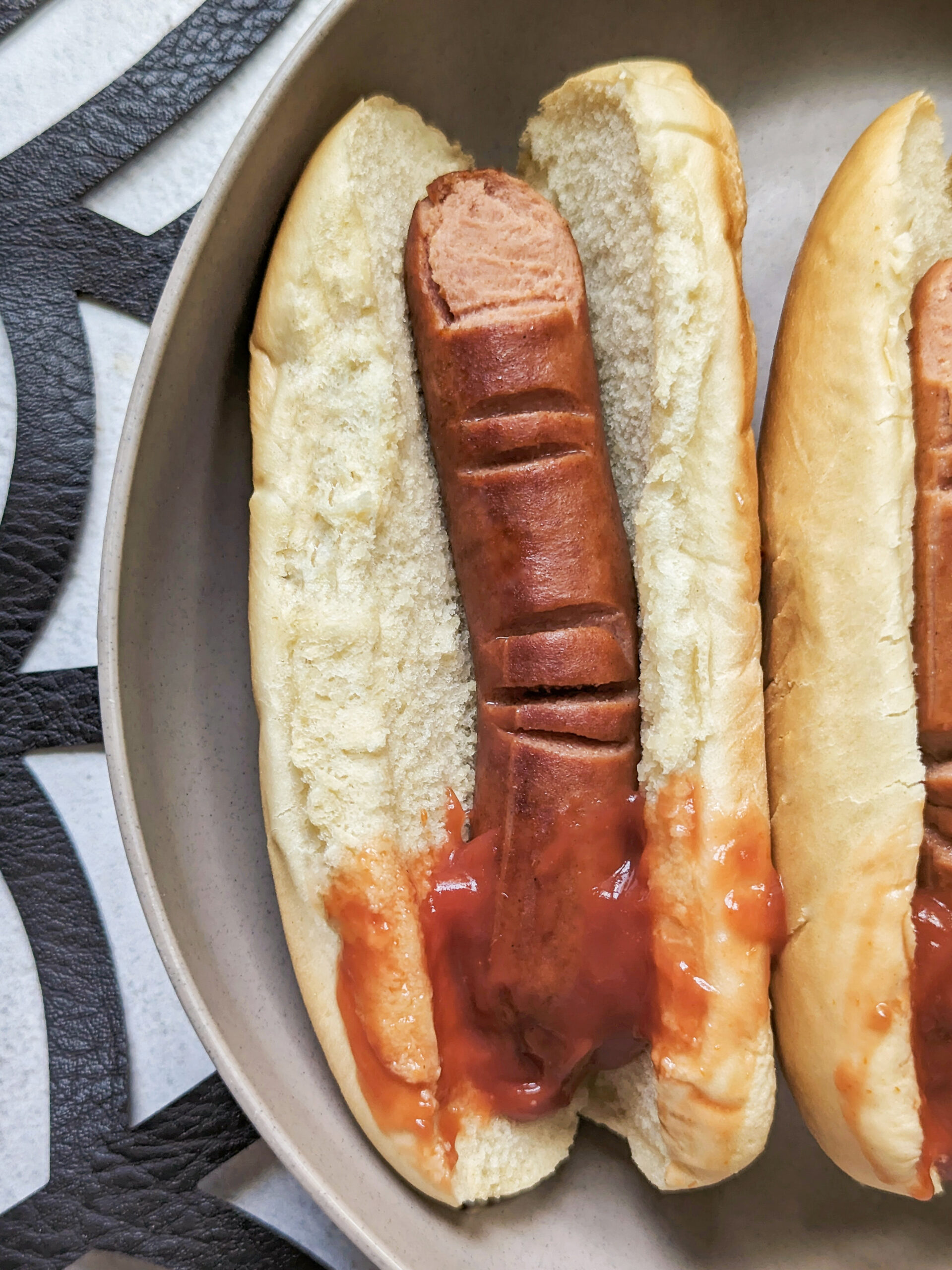 Halloween Hotdog Fingers in between hotdog buns with ketchup.
