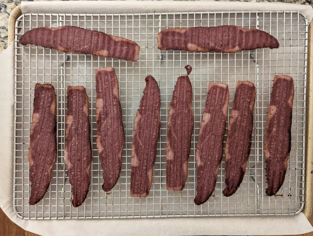 Turkey bacon lined onto a wire rack set into a rimmed baking sheet.