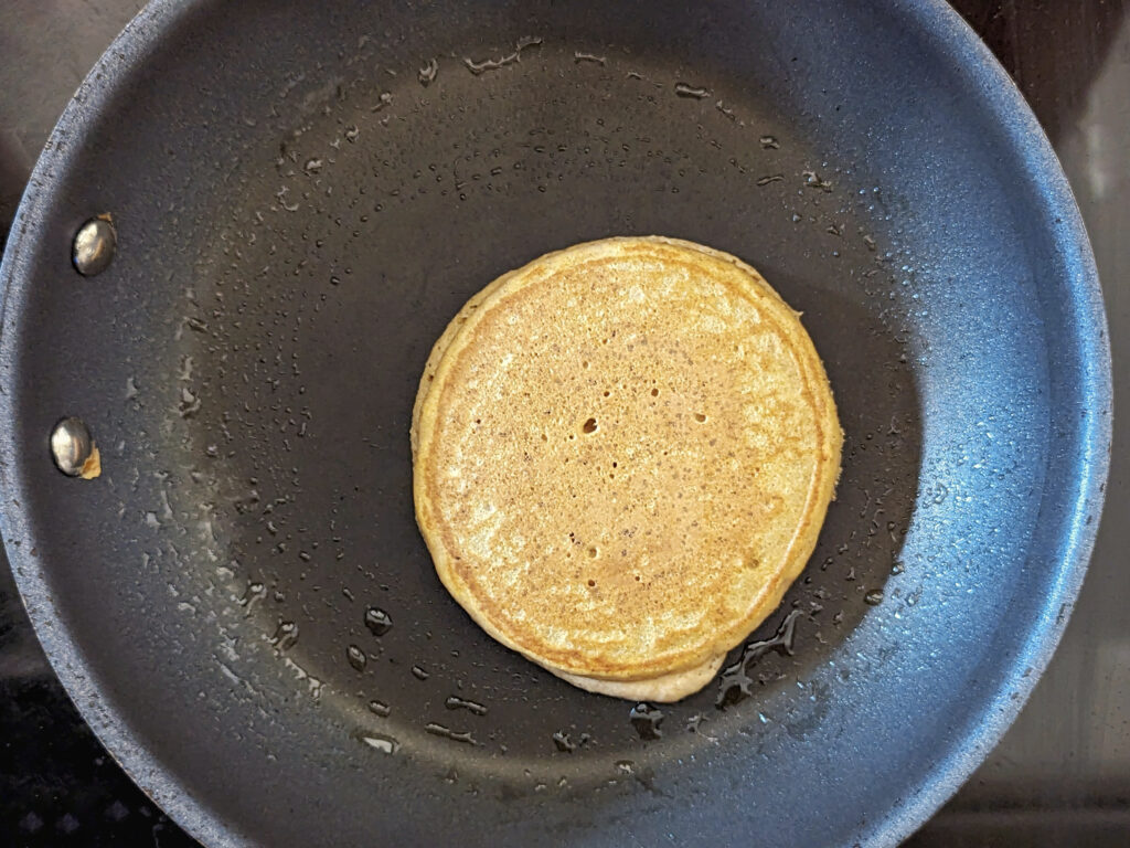 A flipped pancake on a skillet.