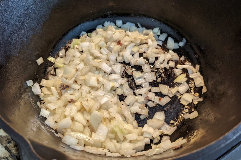 Onions sautéing in oil in the dutch oven.