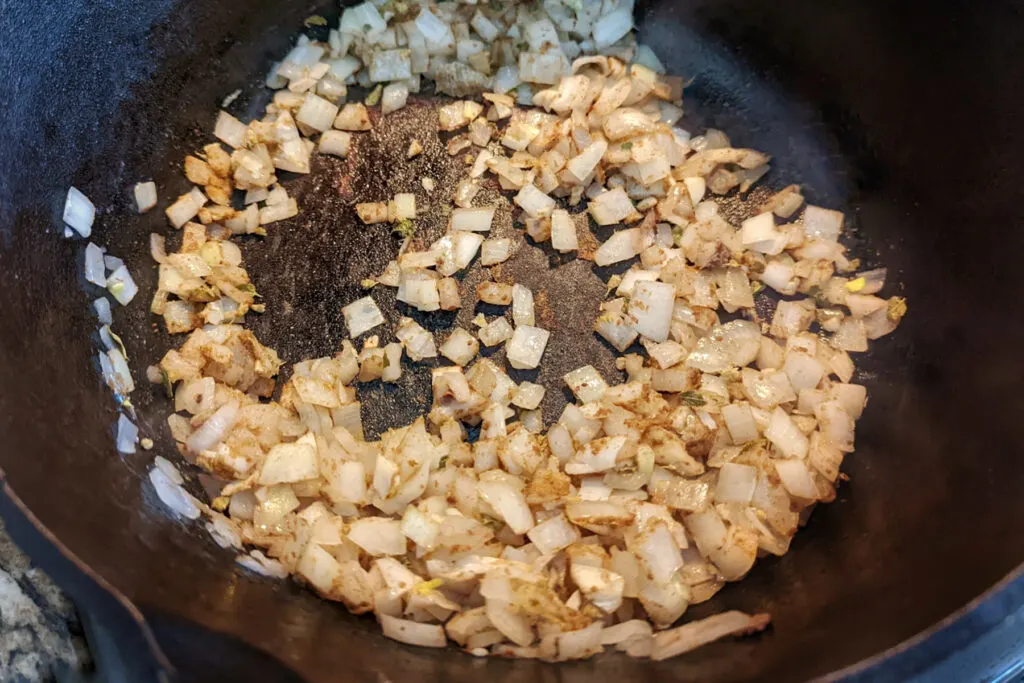 Ground spices added to the sautéed onions.
