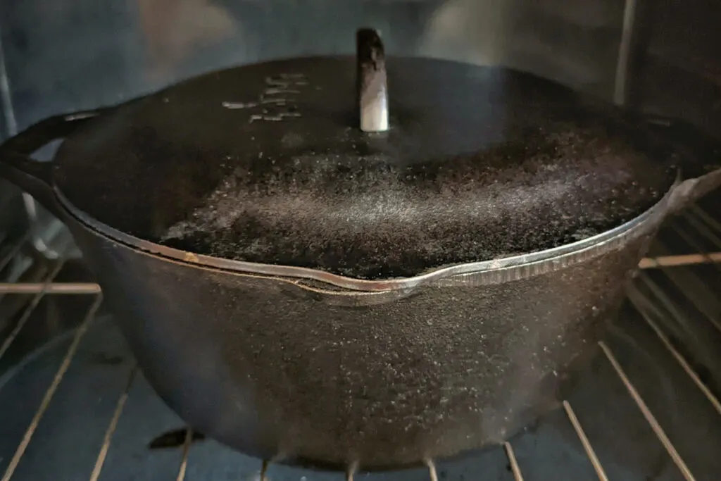 A dutch oven with a lid inside of the oven.