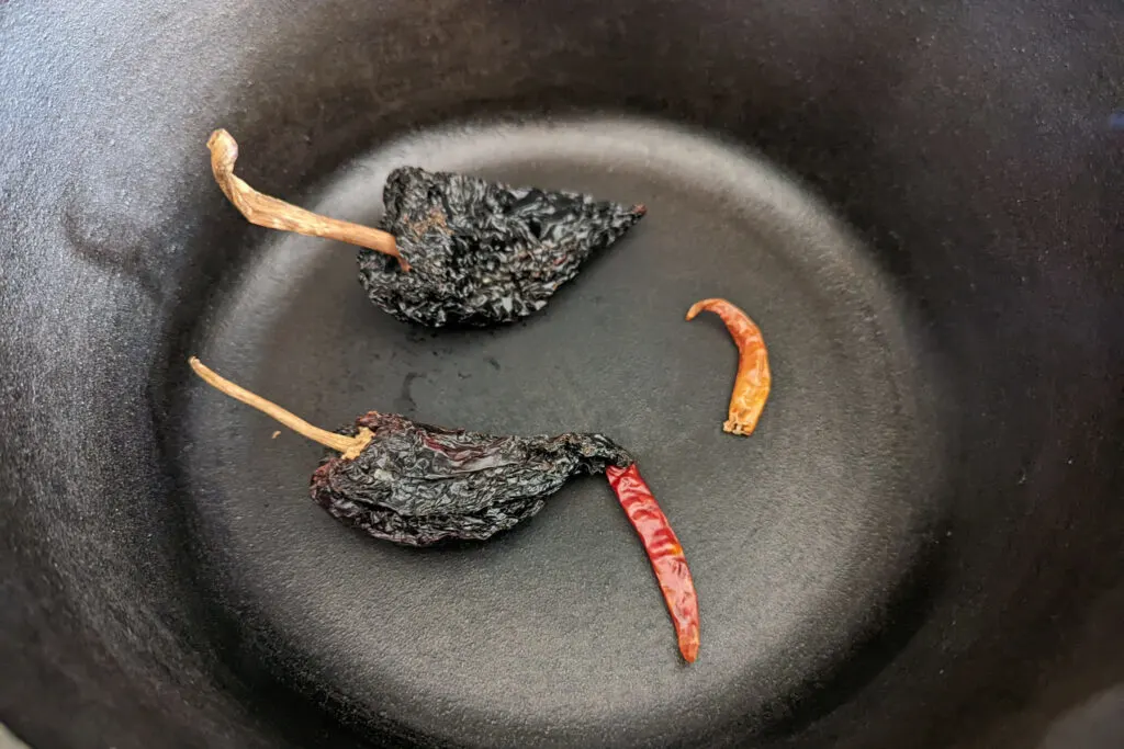 Chilies searing in a dutch oven.