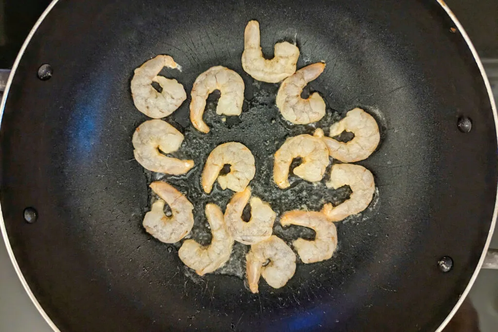 Shrimp searing in a wok.