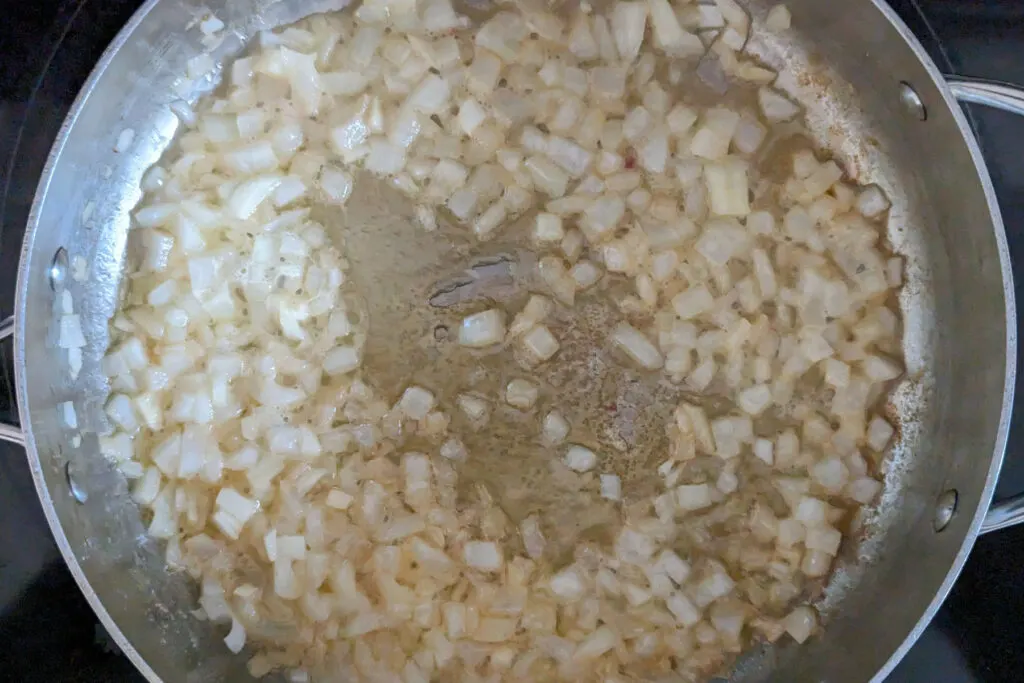 Onions cooking in a saute pan.