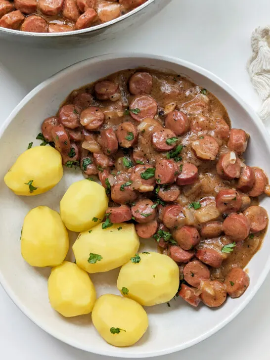 Nakkikastike on a plate with boiled potatoes.