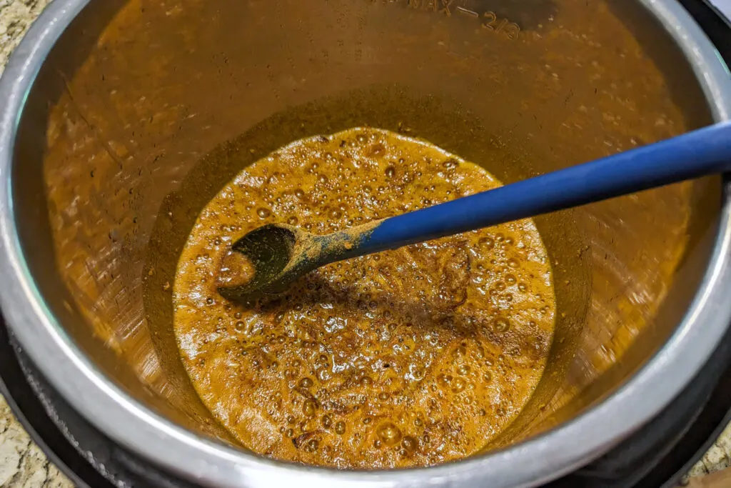 The nihari masala, onions, and garlic in a pot.