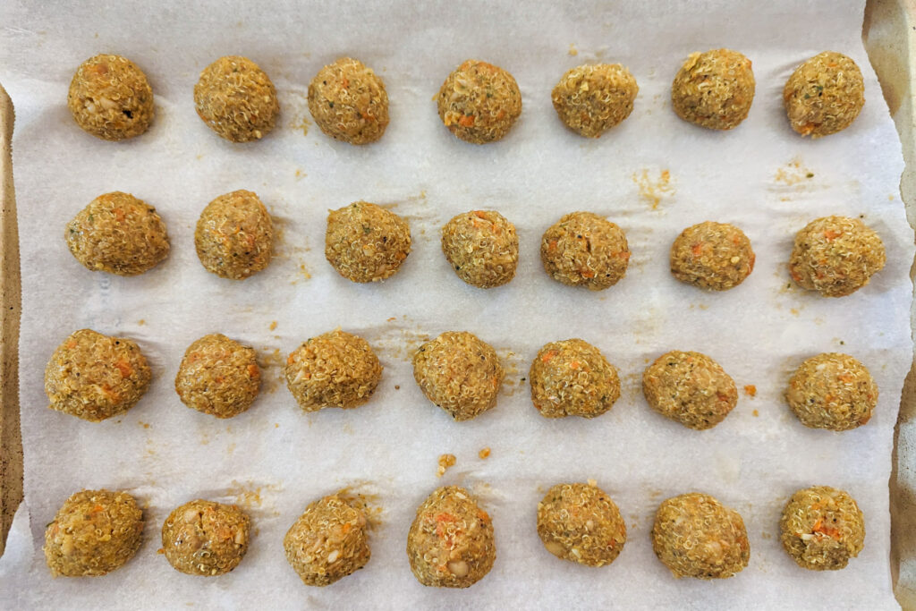 The quinoa mixture rolled into one inch balls on a baking sheet.