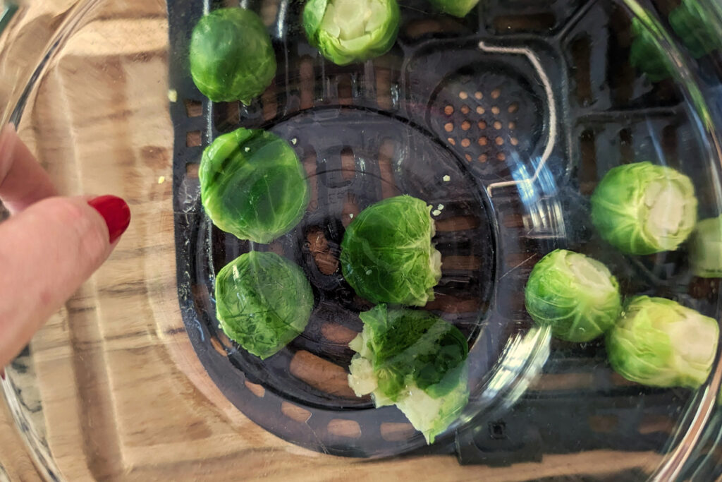 A bowl smashing the Brussels sprouts.