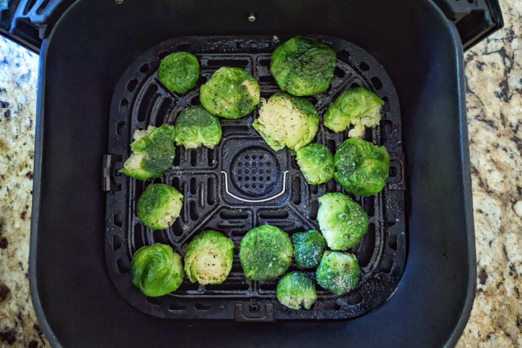 Brussel sprouts lined into an air fryer bsket.