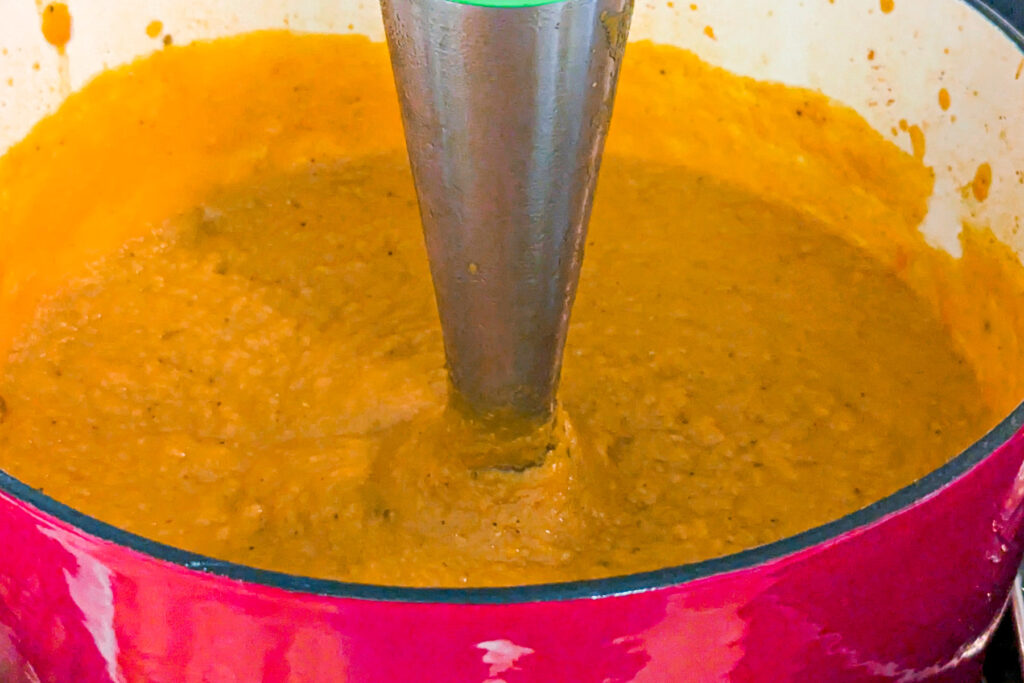Hand held immersion blender pureeing the soup.
