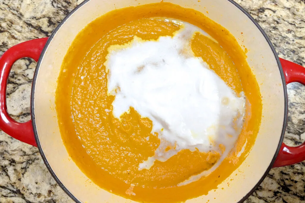 Coconut milk stirred into the carrot pumpkin soup.