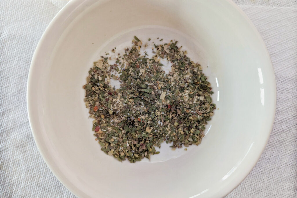 Pizza seasoning in a small bowl.