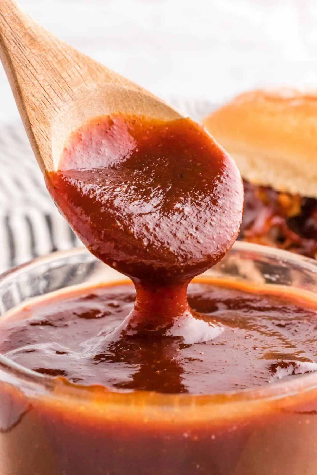 A bowl of bbq sauce with a spoon in it. 