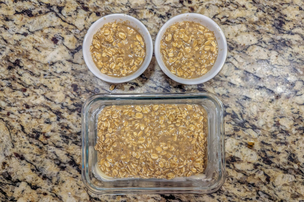 The oatmeal mixture distributed between baking dishes.
