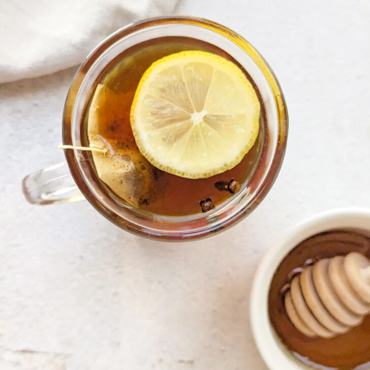 A non alcoholic hot toddy in a glass with lemon.