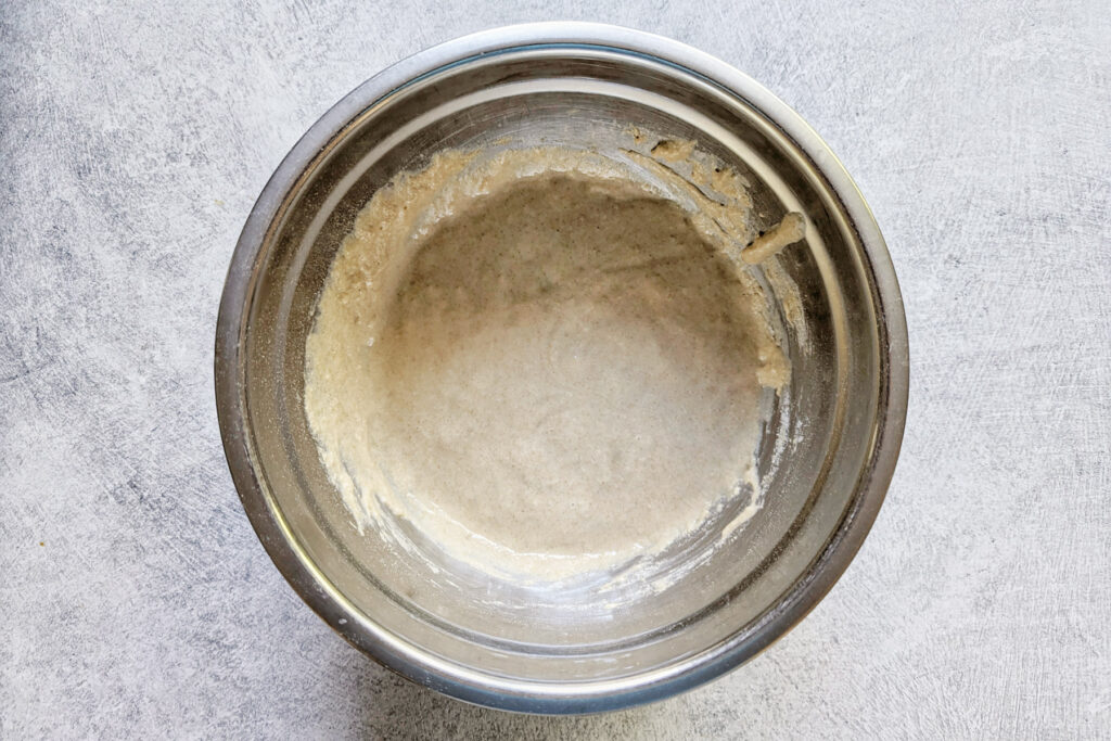Wet and dry ingredients combined in a mixing bowl.